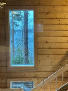 a large window in a log cabin with stairs at Best Cottage in Ruokolahti
