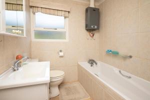 a bathroom with a toilet and a tub and a sink at Leef op Hoop in Boggomsbaai +23 photos