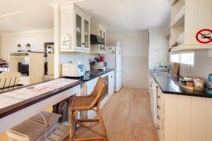 a kitchen with white cabinets and a counter top at Leef op Hoop in Boggomsbaai
