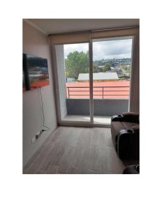 een woonkamer met een groot raam en een televisie bij Condominio Vista Reloncavi in De Cauquenes