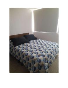 een slaapkamer met een bed met een blauw dekbed bij Condominio Vista Reloncavi in De Cauquenes