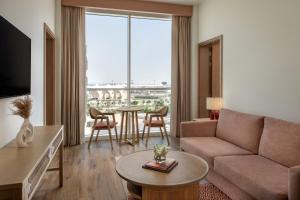 a living room with a couch and a table at Yas Plaza Circuit by IHG in Abu Dhabi