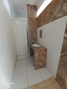 een badkamer met een wastafel en een stenen muur bij Beach House in Punta Negra