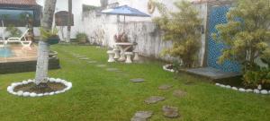 a backyard with a garden with an umbrella at SUITE ACONCHEGANTE 02 in Saquarema