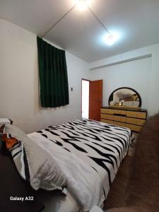 een slaapkamer met een bed, een ladekast en een spiegel bij Beach House in Punta Negra