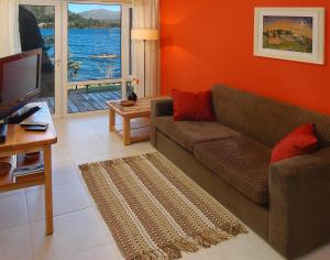 uma sala de estar com um sofá e uma televisão em Refugio del Lago em San Carlos de Bariloche