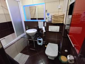 a bathroom with a white toilet and a sink at APARTAMENT VENGE -CAŁE MIESZKANIE 46m2 NA WYŁĄCZNOŚĆ - Z JEDNĄ SYPIALNIĄ I JEDNYM SYPIALNO-SALONEM -3 PIĘTRO BEZ WINDY- REZERWACJA BEZ KARTY KREDYTOWEJ-KLIMATYZACJA-NETFLIX-2 ŁÓŻECZKA DZIECIĘCE, BEZPŁATNY PARKING PUBLICZNY NA MONITOROWANYM PODWÓRZU in Wrocław