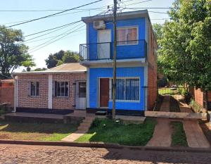 a blue house sitting on the side of a street at La Esperanza in Puerto Esperanza