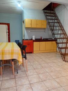 eine Küche mit gelben Schränken und einem Tisch in einem Zimmer in der Unterkunft La Esperanza in Puerto Esperanza