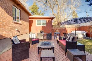 a patio with chairs and tables and an umbrella at Hot Tub and Walk to Midtown! Reno Retreat in Reno
