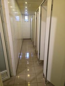 a hallway of stalls in a building with a tile floor at The Hostel in Kyiv