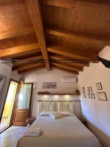een slaapkamer met een groot bed en houten plafonds bij Agriturismo La Boschina in Crema