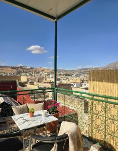 a balcony with a table and a view of a city at Riad Dalia - Fes Medina in Fez