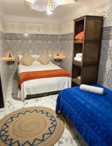 a bedroom with two beds and a book shelf at Riad Dalia - Fes Medina in Fez