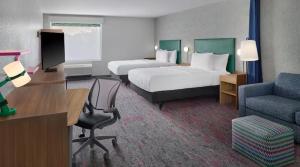 a hotel room with two beds and a desk at Home 2 Suites by Hilton Frankenmuth in Frankenmuth