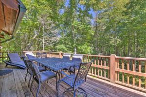 een houten terras met een tafel en stoelen erop bij Rustic Lodge with Views, Decks and Game Room in Sapphire