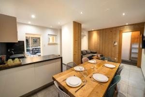 a kitchen and dining room with a wooden table at Gite Le ptit plus à Gérardmer in Gérardmer