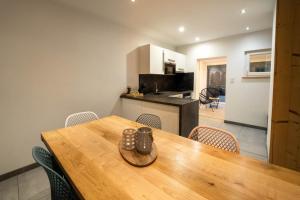 a kitchen and dining room with a wooden table and chairs at Gite Le ptit plus à Gérardmer in Gérardmer +21 photos