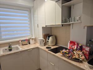 a kitchen with white cabinets and a sink and a counter top at ZenCozy Studio - Free Underground Parking in Bucharest
