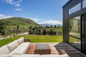 a living room with a couch and a view of a yard at Te Maunga Retreat | Views, Space & Near Ski Fields in Frankton