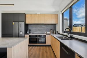 a kitchen with wooden cabinets and a large window at Te Maunga Retreat | Views, Space & Near Ski Fields in Frankton