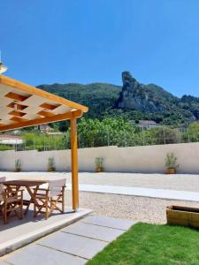 a patio with a table and chairs and a mountain at Villa Eleni Apartment no2 in Agios Gordios