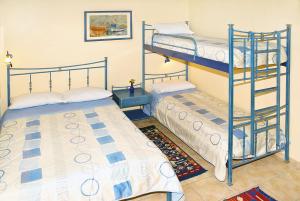 1 Schlafzimmer mit 2 Etagenbetten und einem Teppich in der Unterkunft Melistas Rooms in Marathias