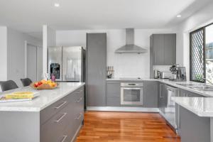 a kitchen with stainless steel appliances and a wooden floor at Goonawarra Getaway at Mooloolaba in Mooloolaba