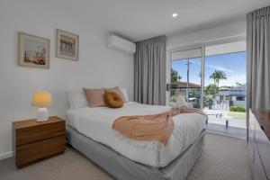 a bedroom with a bed and a large window at Goonawarra Getaway at Mooloolaba in Mooloolaba +28 photos