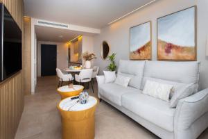 ein Wohnzimmer mit einer weißen Couch und einem Tisch in der Unterkunft Le Petit Palace in Guadalupe