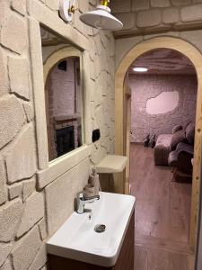 Leśna Grota na Roztoczu في Górecko Stare: حمام مع حوض وجدار حجري +21 صورة