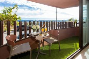 ein Balkon mit Tisch und Stühlen und einem großen Fenster in der Unterkunft Le Petit Palace in Guadalupe