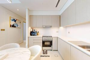 eine Küche mit weißen Schränken und einem Herd in der Unterkunft DIRECT BURJ KHALIFA ONLY 2 MINUTES AWAY in Dubai