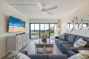 YbelSand Pointe 226的客厅里有一张蓝色沙发和一台吊扇