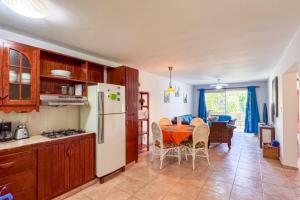 a kitchen with a table and a white refrigerator at Renaissance Residence Cabarete in Cabarete