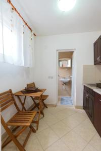 a kitchen with a table and a chair and a sink at Apartments Lora in Bar