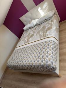 een klein bed in een kamer met paarse muren bij Loft Appartement Les Angles 30133 Possibilité jacuzzi in Les Angles Gard