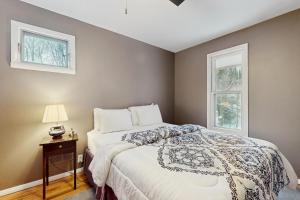 a bedroom with a bed and two windows at Deer Hill Retreat in Whitingham