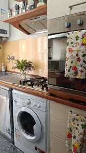 eine Küche mit einem Herd und einer Waschmaschine in der Unterkunft Centurion's House in Genua