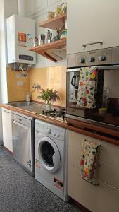 een keuken met een fornuis en een wasmachine bij Centurion's House in Genua