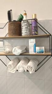 een plank met handdoeken en andere badkamerartikelen erop bij Centurion's House in Genua