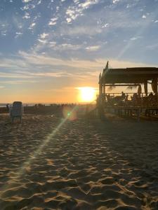 un tramonto su una spiaggia con una sedia sulla sabbia di Complejo Bosque Verde a La Porteña