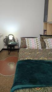 een slaapkamer met een groen bed met kussens en een tafel bij Centurion's House in Genua