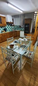 a glass table in a kitchen with two chairs at Le spacieux in Cherbourg en Cotentin