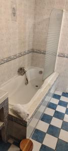a bath tub with a faucet in a bathroom at Le spacieux in Cherbourg en Cotentin