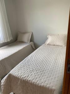 two beds sitting next to each other in a room at Estância da Colina Chalet in Venda Nova do Imigrante