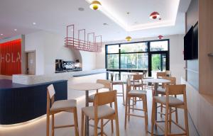 Un comedor con mesas y sillas en un restaurante. en Holiday Inn Express & Suites Barcelona - Sabadell by IHG, en Sabadell