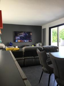 ein Wohnzimmer mit Sofa und Fernseher in der Unterkunft Villa piscine carnon plage in Mauguio