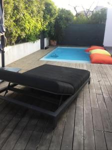 ein Bett auf einer Terrasse neben einem Pool in der Unterkunft Villa piscine carnon plage in Mauguio