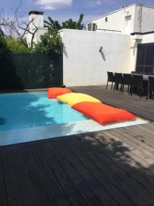 einen Pool mit bunten Kissen auf einer Terrasse in der Unterkunft Villa piscine carnon plage in Mauguio